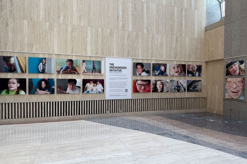 The Undiagnosed Initiative – Photo Exhibition displayed in a large indoor atrium, showing portraits of children, individuals, and families living with undiagnosed diseases.